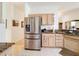 Stainless steel refrigerator in kitchen with light wood cabinets at 512 Heartwell Dr, Poinciana, FL 34759