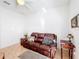 Living room features a brown leather couch and ceiling fan at 512 Heartwell Dr, Poinciana, FL 34759