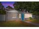 Updated bungalow exterior with gray siding, blue door, and landscaped yard at 907 Columbia St, Orlando, FL 32805