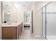 Bathroom featuring a double sink vanity, glass shower, and open view to the bedroom at 9475 Randal Park Blvd, Orlando, FL 32832