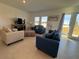Bright living room with tile floors, two sofas, and access to backyard at 1625 Hill Park Dr, Deltona, FL 32725