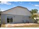 View of a cozy backyard with a stone patio and sliding glass doors for indoor-outdoor living at 1804 Westminster Trl, Clermont, FL 34714