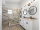 Modern bathroom features a double vanity with marble countertops and a frameless glass shower at 1804 Westminster Trl, Clermont, FL 34714