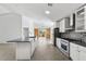 Bright kitchen with island, stainless steel appliances, white cabinets, and a large sliding barn door at 1804 Westminster Trl, Clermont, FL 34714