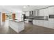 Open kitchen with a sleek island, stainless appliances, modern cabinetry, and a decorative backsplash at 1804 Westminster Trl, Clermont, FL 34714