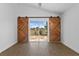 Cozy living area featuring unique sliding barn doors that open to the outdoors, providing ample natural light at 1804 Westminster Trl, Clermont, FL 34714
