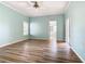 Bright bedroom with wood-look floors, ceiling fan, and sliding glass doors at 243 New River Dr, Kissimmee, FL 34759