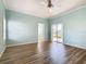 Spacious bedroom featuring light walls, wood-look floors, and a view to the backyard at 243 New River Dr, Kissimmee, FL 34759