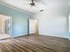 Bedroom with light walls, wood-look floors, and access to a patio at 243 New River Dr, Kissimmee, FL 34759