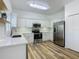 Modern kitchen with white cabinets, stainless steel appliances, and wood-look floors at 243 New River Dr, Kissimmee, FL 34759