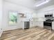 Modern kitchen with white cabinets, stainless steel appliances, and wood-look floors at 243 New River Dr, Kissimmee, FL 34759