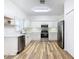 Modern kitchen with white cabinets, stainless steel appliances, and wood-look floors at 243 New River Dr, Kissimmee, FL 34759