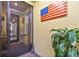 Screened entryway with a welcoming atmosphere, featuring an American flag and potted plant at 2448 Palm Tree Dr, Kissimmee, FL 34759