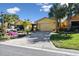 House exterior with yellow walls, double garage, and landscaping at 2448 Palm Tree Dr, Kissimmee, FL 34759
