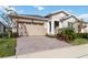 Tan house with a two-car garage and attractive landscaping at 2756 Greenlands St, St Cloud, FL 34772