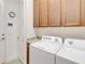 Bright laundry room with washer, dryer, and cabinets at 2756 Greenlands St, St Cloud, FL 34772