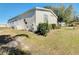 Side view of the mobile home showcasing landscaping at 301 Evandee Ct, Kissimmee, FL 34758