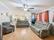 Open living room with hardwood floors, gray sofas, and a fish tank at 301 Evandee Ct, Kissimmee, FL 34758