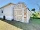 Tan storage shed with double doors in the backyard at 301 Evandee Ct, Kissimmee, FL 34758