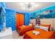 Two twin beds in a themed bedroom with ocean mural and orange bedding at 4154 Lana Ave, Davenport, FL 33897