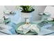 Elegant dining table setting with glass top and green accents at 4154 Lana Ave, Davenport, FL 33897