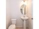 Small powder room with pedestal sink, toilet and oval mirror at 437 Seattle Slew Dr, Davenport, FL 33837