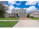 Two-story house with gray siding, brick driveway, and landscaped lawn at 437 Seattle Slew Dr, Davenport, FL 33837