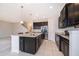 Modern kitchen with dark cabinets, granite counters and island at 437 Seattle Slew Dr, Davenport, FL 33837