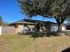 Single-story home with a large tree, attached garage, and fenced yard at 511 Kilimanjaro Dr, Kissimmee, FL 34758
