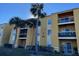 Two-story condo building with palm trees and landscaping at 5275 Images Cir # 204, Kissimmee, FL 34746