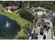 Aerial view of the community entrance, pool, clubhouse, lake with fountain, and lush tropical landscaping at 8557 La Isla Dr, Kissimmee, FL 34747