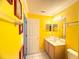 Bright bathroom with yellow walls featuring a vanity, toilet, and enclosed shower stall at 8557 La Isla Dr, Kissimmee, FL 34747