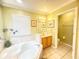 Bright bathroom displaying a soaking tub, adjacent sink vanity, and an open doorway to the toilet at 8557 La Isla Dr, Kissimmee, FL 34747