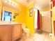 Bathroom with a vanity, mirror, toilet, and enclosed shower stall with patterned curtain at 8557 La Isla Dr, Kissimmee, FL 34747
