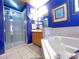 Bright bathroom featuring a garden tub, glass enclosed shower, and blue walls at 8557 La Isla Dr, Kissimmee, FL 34747