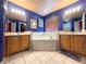 Bathroom featuring dual sink vanities, a neutral tiled soaking tub, and tiled flooring at 8557 La Isla Dr, Kissimmee, FL 34747