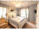 Comfortable bedroom with soft blue walls, white furniture, and a bright window at 8557 La Isla Dr, Kissimmee, FL 34747