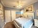 Comfortable bedroom with soft blue walls, white furniture, and nautical themed artwork at 8557 La Isla Dr, Kissimmee, FL 34747