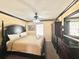 King-size bed, ceiling fan, and built-in storage at 8557 La Isla Dr, Kissimmee, FL 34747