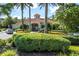 Clubhouse with lush, well-manicured landscaping featuring flowering shrubs and palm trees at 8557 La Isla Dr, Kissimmee, FL 34747