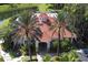 Aerial view of the clubhouse featuring a tile roof, manicured landscaping, and palm trees at 8557 La Isla Dr, Kissimmee, FL 34747