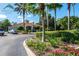 View of the clubhouse featuring manicured landscaping, flowering shrubs, and palm trees at 8557 La Isla Dr, Kissimmee, FL 34747