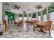 Bright dining area featuring multiple tables, ceiling fans, and views of the lush tropical landscape at 8557 La Isla Dr, Kissimmee, FL 34747