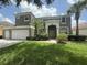 Beautiful two-story home featuring a three car garage, lush lawn, and tropical landscaping at 8557 La Isla Dr, Kissimmee, FL 34747