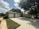 Exterior shot of a home featuring a large three-car garage and long driveway at 8557 La Isla Dr, Kissimmee, FL 34747