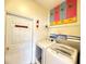 Bright laundry room includes modern washer and dryer with decorative art at 8557 La Isla Dr, Kissimmee, FL 34747