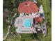 Aerial view of the pool area with palm trees, lounge chairs, tables, and a spa at 8557 La Isla Dr, Kissimmee, FL 34747