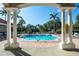 Framed view of the pool area with palm trees, lounge chairs, and a clear blue sky at 8557 La Isla Dr, Kissimmee, FL 34747