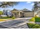 House exterior showcasing a light tan color, stone accents, and a 2 car garage at 8737 Leeland Archer Blvd, Orlando, FL 32836