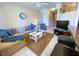 Tan sectional sofa, coffee table, and view of kitchen and hallway at 904 Assembly Ct, Reunion, FL 34747